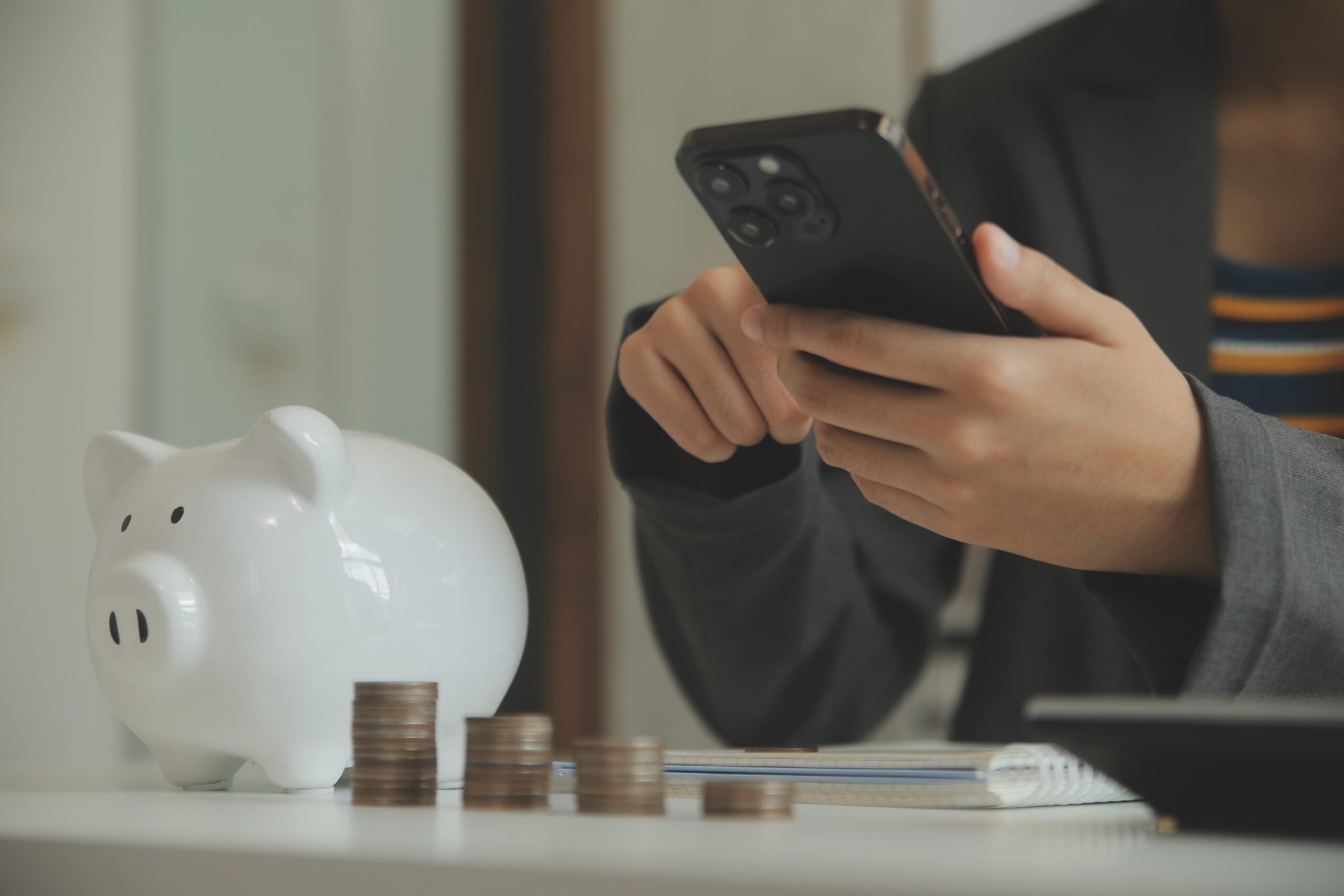 Geld besparen op een Spotify account door te delen via SameSubs, afgebeeld met een spaarpot en smartphone.